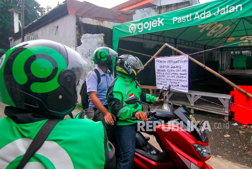 Pengendara ojek online melihat pengumuman penutupan shalter sementara di Stasiun Depok Lama, Depok, Jawa Barat, Senin (16/3/2020). (Antara/Asprilla Dwi Adha)