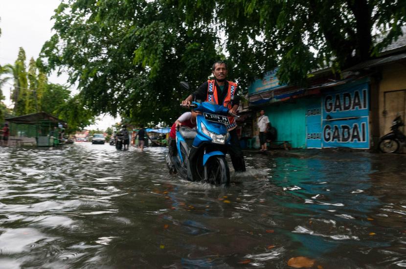 Pengendara roda dua mendorong motornya yang mogok akibat terendam banjir di Rangkasbitung, Lebak, Banten (ilustrasi)