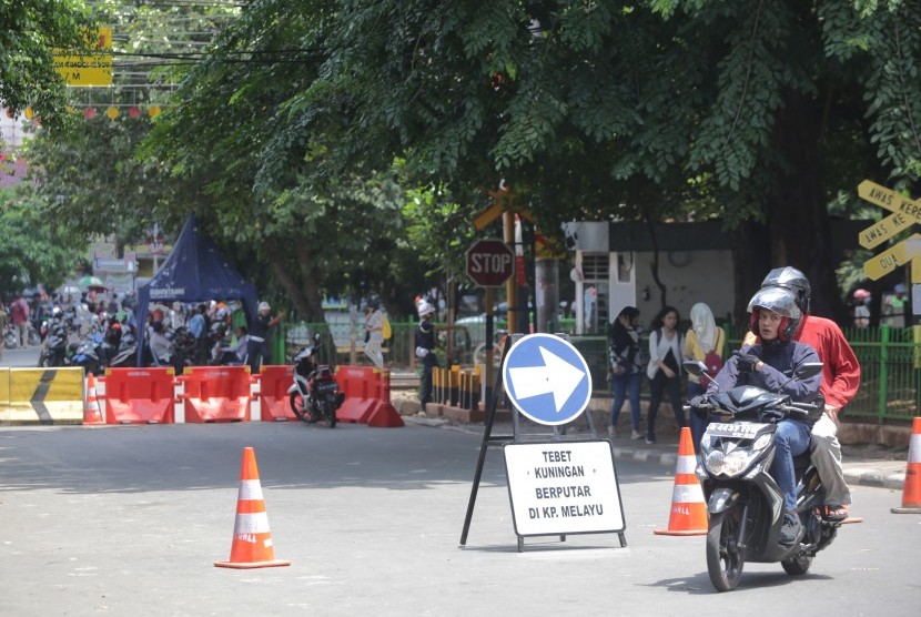Pengendara sepeda motor berputar arah saat akan melintas di jalur perlintasan kereta api listrik (KRL) yang sudah ditutup di pintu perlintasan stasiun Tebet Jalan Abdullah Syafii, Jakarta Selatan, Kamis (7/4).