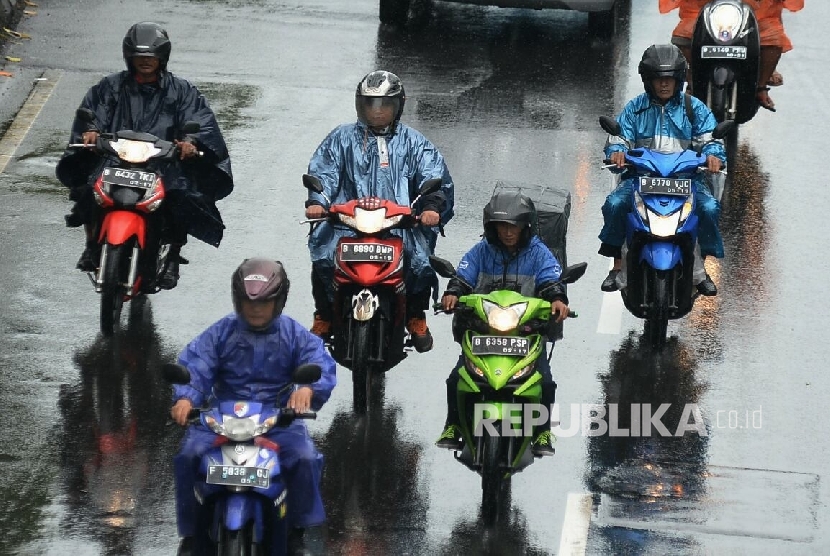  Pengendara sepeda motor dengan menggunakan jas hujan menerobos hujan di Kawasan Salemba, Jakarta. ilustrasi