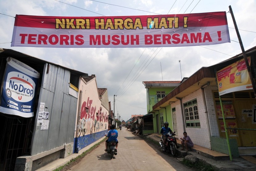  Pengendara sepeda motor melaju di bawah spanduk berisi penolakan terhadap teroris di Desa Pegirikan, Kabupaten Tegal, Jawa Tengah, Selasa (19/1). 