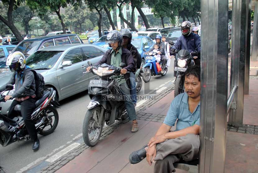   Pengendara sepeda motor melaju di trotoar di Jalan Sudirman, Jakarta Pusat, Jumat (19/7).    (Republika/ Yasin Habibi)