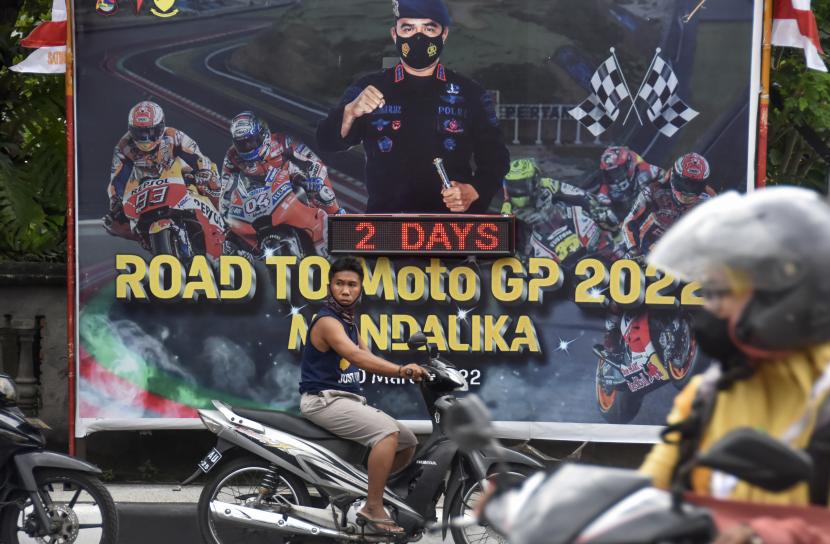 Pengendara sepeda motor melintas di dekat baliho sosialisasi MotoGP yang terpasang di gerbang Mako Satbrimob Polda NTB di Ampenan, Kota Mataram, NTB, Selasa (15/3/2022). Sebanyak 3.427 personel gabungan dari TNI dan Polri yang berasal dari Kepolisian Daerah Nusa Tenggara Barat termasuk jajaran Kepolisian Resor (Polres), Komando Resor Militer dan anggota BKO Mabes Polri dipersiapkan untuk pengamanan Pertamina Grand Prix Of Indonesia (MotoGP) Mandalika pada 18-20 Maret mendatang. 