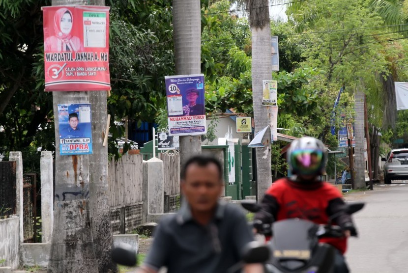 Pengendara sepeda motor melintas di jalan yang masih terdapat Alat Peraga Kampanye (ilustrasi)