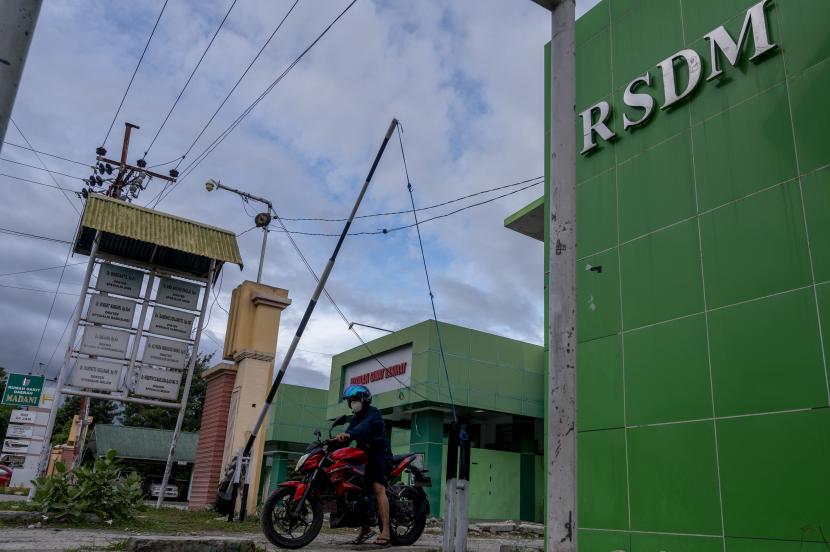 Pengendara sepeda motor melintasi gerbang Rumah Sakit Daerah (RSD) Madani di Palu, Sulawesi Tengah, Jumat (18/6/2021). Rumah sakit yang dikelola Pemerintah Kota Palu itu terpaksa menghentikan sementara layanan rawat inap sejak dua hari terakhir ini untuk meminimalisir penyebaran virus corona menyusul terinfeksinya sejumlah tenaga kesehatan di rumah sakit tersebut.