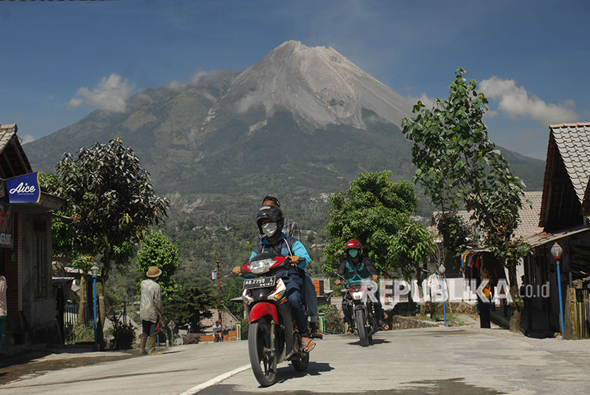 Pengendara sepeda motor memakai masker saat melintas di jalan raya yang tertutup abu vulkanis Gunung Merapi di Wonolelo, Sawangan, Magelang, Jawa Tengah, Jumat (1/6). 