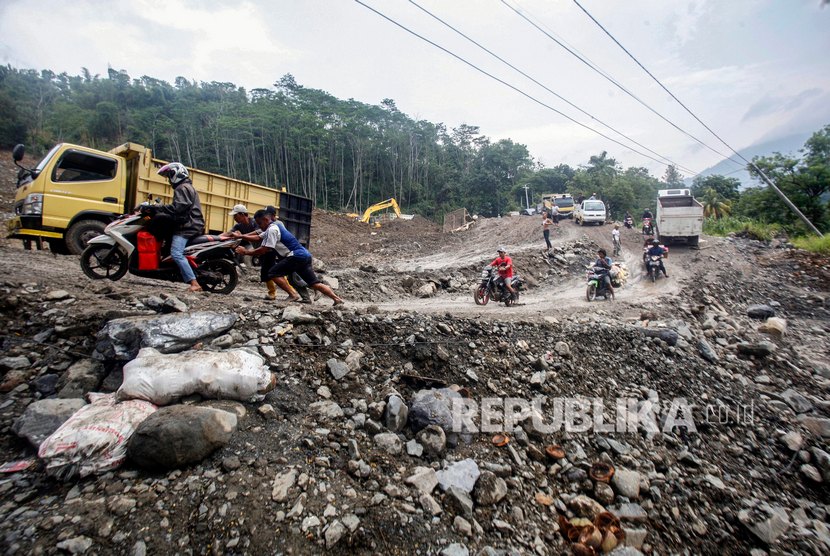 Pengendara sepeda motor memaksakan diri untuk melintasi jalan Transyogi yang longsor di Tanjung Sari, Kabupaten Bogor, Jawa Barat. (Ilustrasi)