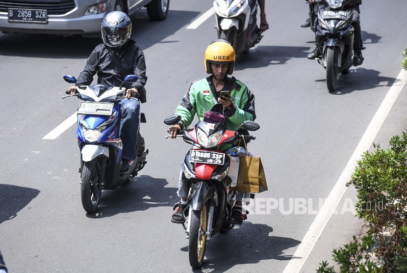 Pengendara sepeda motor mengamati aplikasi GPS (pelacak jalan) di gawainya saat berkendara di Jalan Rasuna Said, Kuningan, Jakarta, Kamis (7/2/2019). 