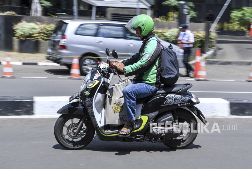 Pengendara sepeda motor mengamati aplikasi GPS (pelacak jalan) di gawainya saat berkendara di Jalan Rasuna Said, Kuningan, Jakarta, Kamis (7/2/2019).