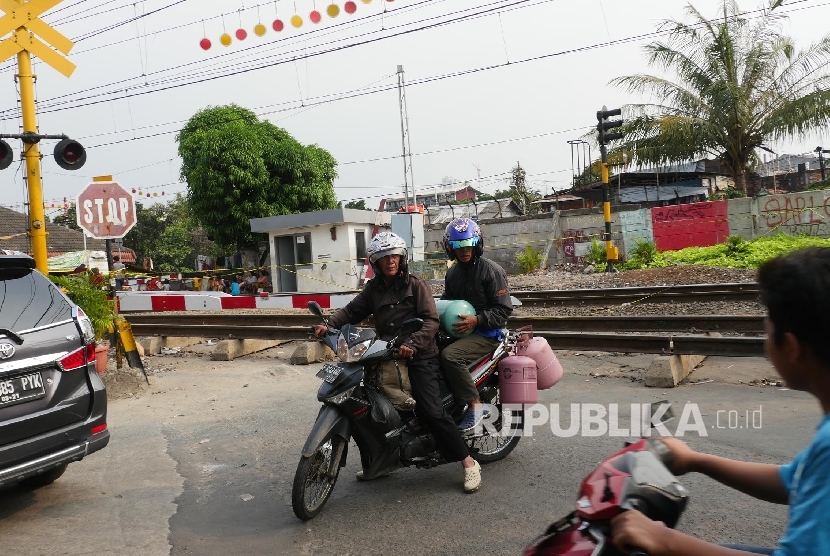 Pengendara sepeda motor terpaksa berbalik arah saat akan melewati perlintasan kereta api sebidang JPL No. 31 di Jl tanah Tinggi 1, Jakarta yang ditutup.