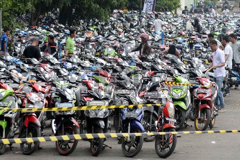 Calon pemudik motor gratis mengepak motor yang akan diangkut ke kota masing-masing di halaman parkir Bulog, Jakarta Timur, Jumat (10/7). (Republika/Yasin Habibi)