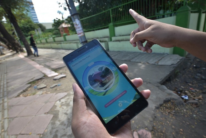 Penggemar gim berburu pokemon di layar androidnya (ilustrasi) 