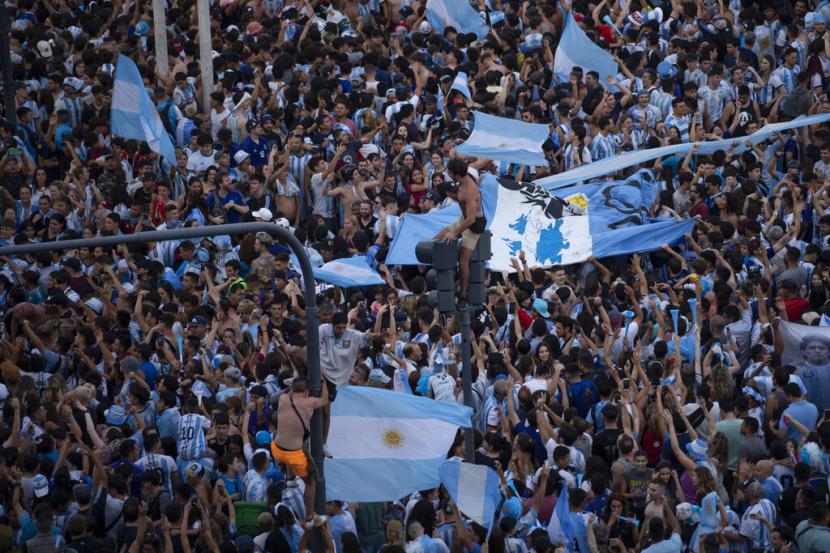  Penggemar sepak bola Argentina merayakan kemenangan tim nasionalnya atas Kroasia dalam pertandingan semifinal Piala Dunia 2022, di Obelisk, di pusat kota Buenos Aires, Argentina, Rabu (14/12) dini hari WIB. 