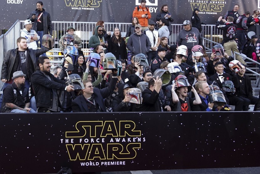 Penggemar Star Wars mengangkat helm mereka saat penayangan perdana Star Wars: Force Awakens di Los Angeles, Senin waktu AS (14/12).