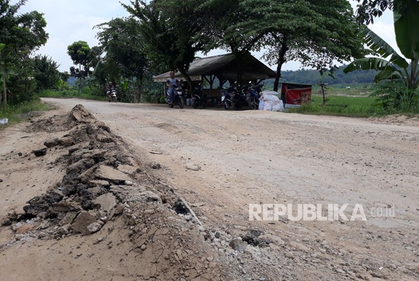 Pengguna jalan dan kontainer melintasi jalan lingkar barat KM 0 yang kondisinya rusak parah, di Kampung Cikadu, Desa Kadu Mekar, Kecamatan Babakan Cikao, Purwakarta, Rabu (14/3). 