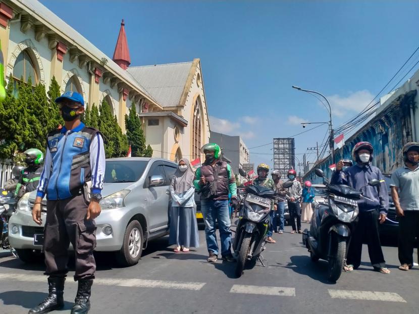 Pengguna jalan di Kota Malang menyanyikan lagu Indonesia Raya di sekitar Alun-Alun Kota Malang, Selasa (17/8). 
