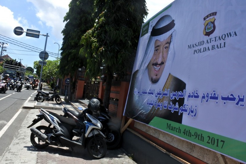 Pengguna jalan melintas di dekat baliho bergambar Raja Arab Saudi Salman bin Abdulaziz al-Saud di kantor Polda Bali.
