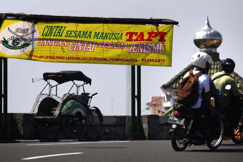 Pengguna jalan melintas di dekat spanduk berisi penolakan kepada kelompok Lesbian, Gay, Biseksual dan Transgender (LGBT)