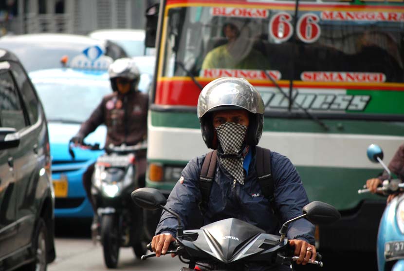 Pengguna kendaraan bermotor menggunakan masker guna mengantisipasi polusi yang terhirup di Jalan Rasuna Said, Jakarta Selatan, Kamis (12/6).