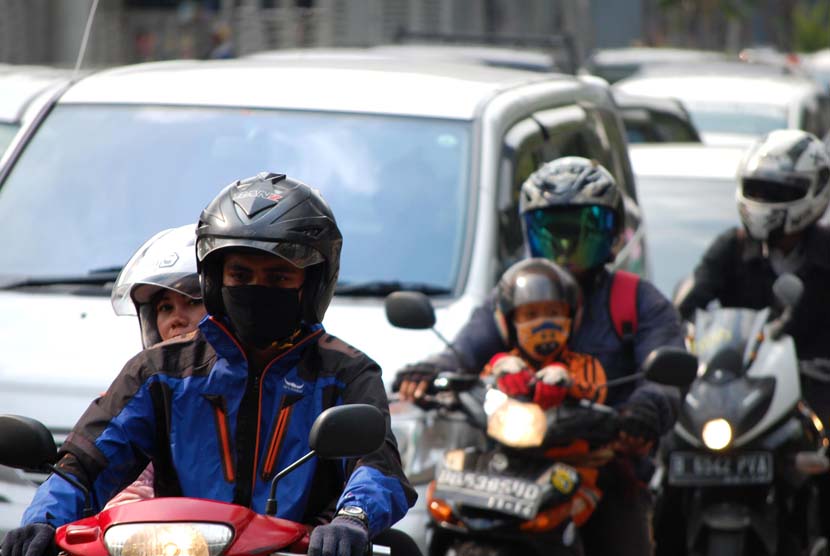 Pengguna kendaraan bermotor menggunakan masker guna mengantisipasi polusi yang terhirup di Jalan Rasuna Said, Jakarta Selatan, Kamis (12/6).