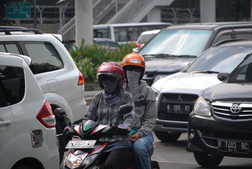 Pengguna kendaraan bermotor menggunakan masker guna mengantisipasi polusi yang terhirup di Jalan Rasuna Said, Jakarta Selatan.