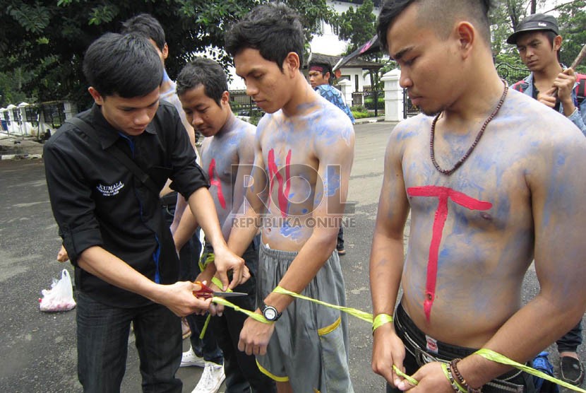  Pengguntingan ikatan sebagi simbol merdekanya Banten dari dinasti politik Ratu Atut pada aksi peduli Banten di depan Gedung Sate, Bandung, Kamis (19/12).   (Republika/Edi Yusuf)