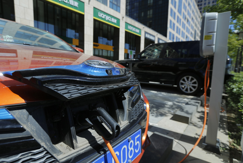 Pengisian kendaraan mobil berbahan bakar listrik di luar sebuah apartemen di Beijing, China, 11 September 2017.