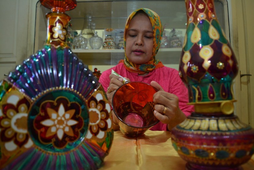 Pengrajin membuat kerajinan gelas lukis di industri rumahan Bluru, Sidoarjo, Jawa Timur, Selasa (10/11).