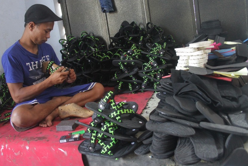 Pengrajin membuat sandal spons untuk selanjutnya dikirim ke Surakarta, Yogyakarta dan Semarang di sentra industri sandal di Toyomarto, Singosari, Malang, Jawa Timur, Senin (13/5/2019).