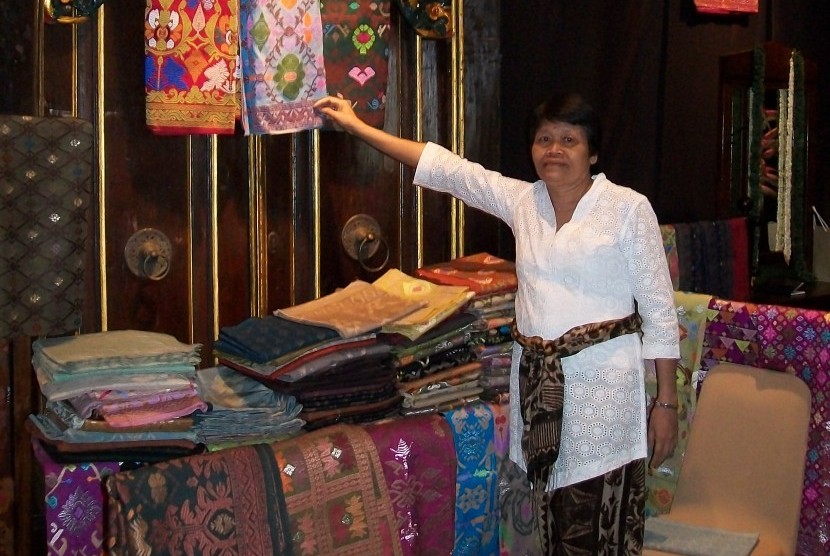 Pengrajin menunjukkan sejumlah kain tradisional Bali.