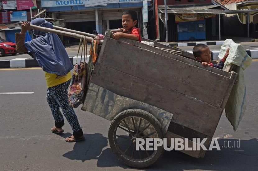 Pengumpul barang bekas menarik gerobak bersama dua anaknya di Kebonjahe, Serang, Banten, Kamis (7/5). Bank Dunia memprediksi sekitar 60 juta orang bisa masuk dalam kemiskinan ekstrem 