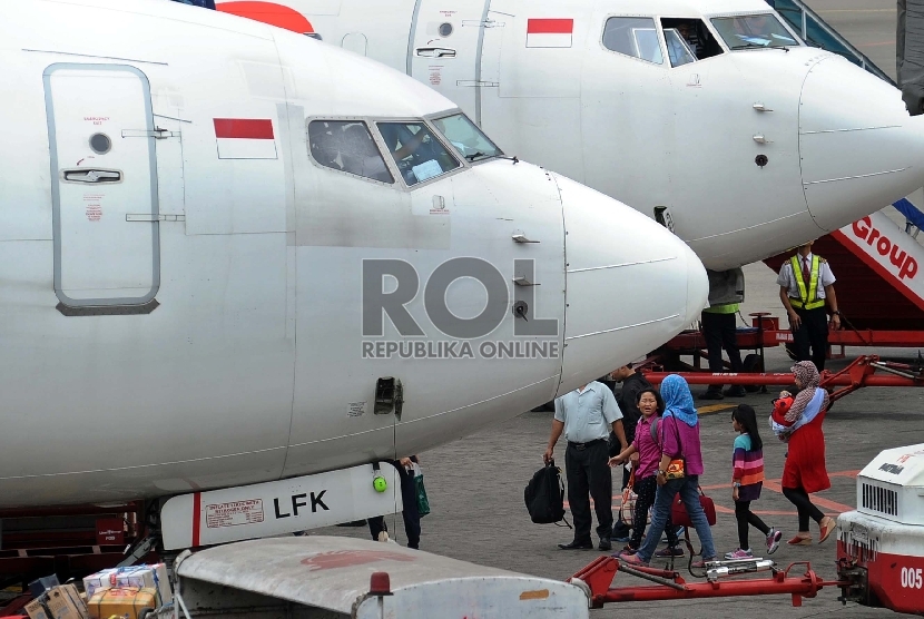 Penguna jasa penerbangan melintas saat akan menaiki pesawat di terminal 1B keberangkatan dalam negeri bandara Internasional Soekarno Hatta, Tangerang, Banten, Selasa (14/7).