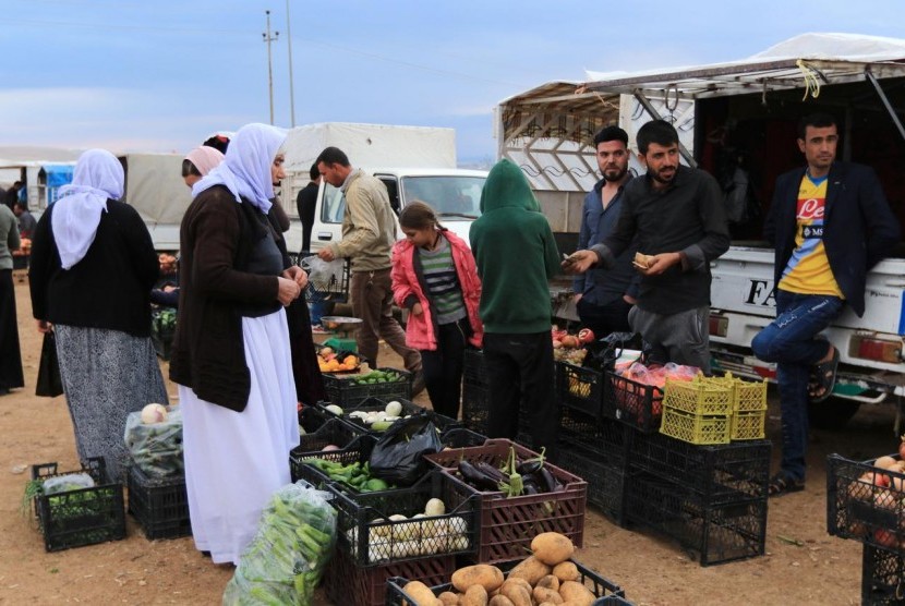 Pengungsi dari agama minoritas Yazidi membeli sayuran di Kamp Sharya di Duhok, Irak, Selasa (29/10).