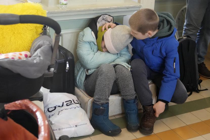 Pengungsi dari Ukraina beristirahat di stasiun kereta api di Przemysl, Polandia, Selasa, 1 Maret 2022.