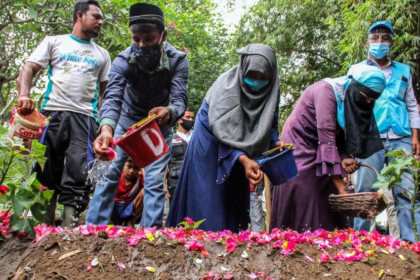 Pengungsi etnis Rohingya menabur bunga usai pemakaman keluarganya di tempat pemakaman umum Desa Kutablang, Lhokseumawe, Aceh, Rabu (9/9/2020). Seorang perempuan etnis Rohingya bernama Nur Khalimah (21) yang merupakan bagian dari 296 orang Rohingya yang terdampar di Aceh pada Senin (7/9/2020) dini hari itu meninggal dunia di tempat penampungan BLK Desa Mee Kandang, Selasa (6/9) sekitar pukul 18.45 WIB karena sakit.