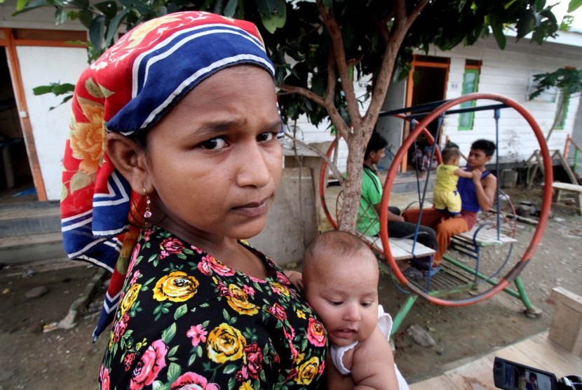 Pengungsi etnis Rohingya yang tersisa beraktivitas dengan anaknya. 