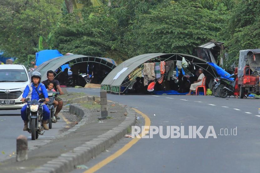 Warga terdampak banjir menempati tenda darurat di jalan raya pantura wilayah Desa Jumbleng, Losarang, Kabupaten Indramayu, Selasa (9/2/2021). 