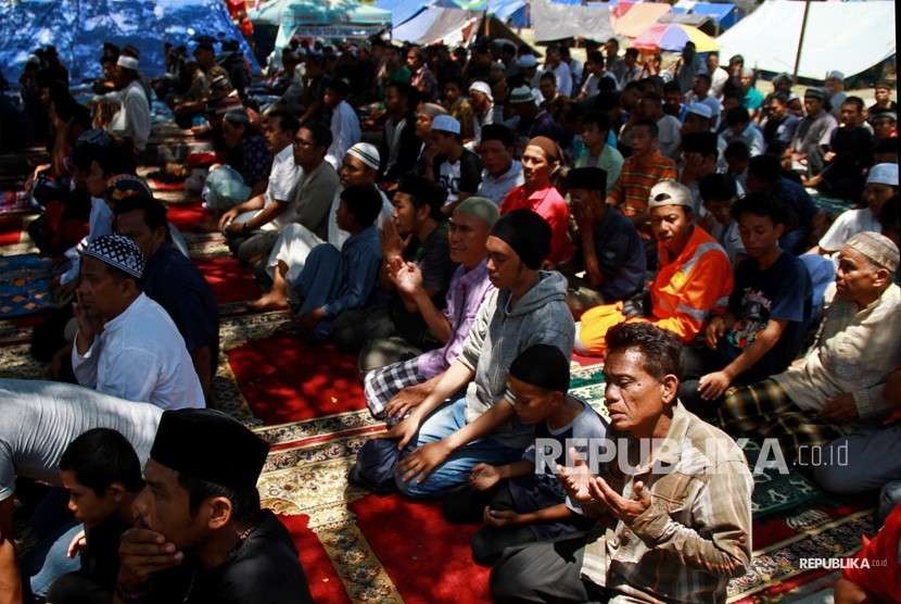 Pengungsi korban gempa dan tsunami melakukan ibadah shalat Jumat di halaman Masjid Agung Palu, Sulawesi Tengah, Jumat (5/10).