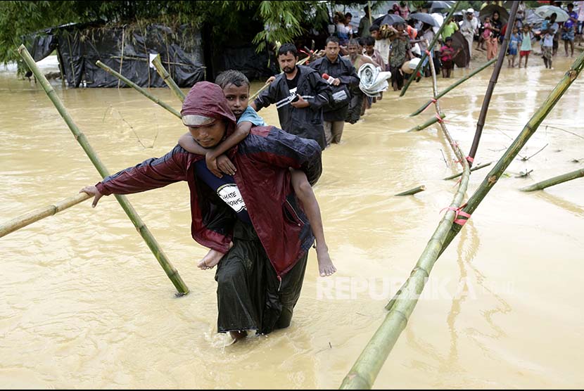 Pengungsi melintasi sungai yang meluap di kamp pengungsi Rohingya di Cox's Bazaar, Bangladesh (Ilustrasi)