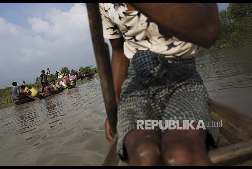 Pengungsi Rohingya menggunakan sampan sewaan setelah melintasi perbatasan Myanmar-Bangladesh dekat Cox's Bazar, Bangladesh, Selasa (5/9)