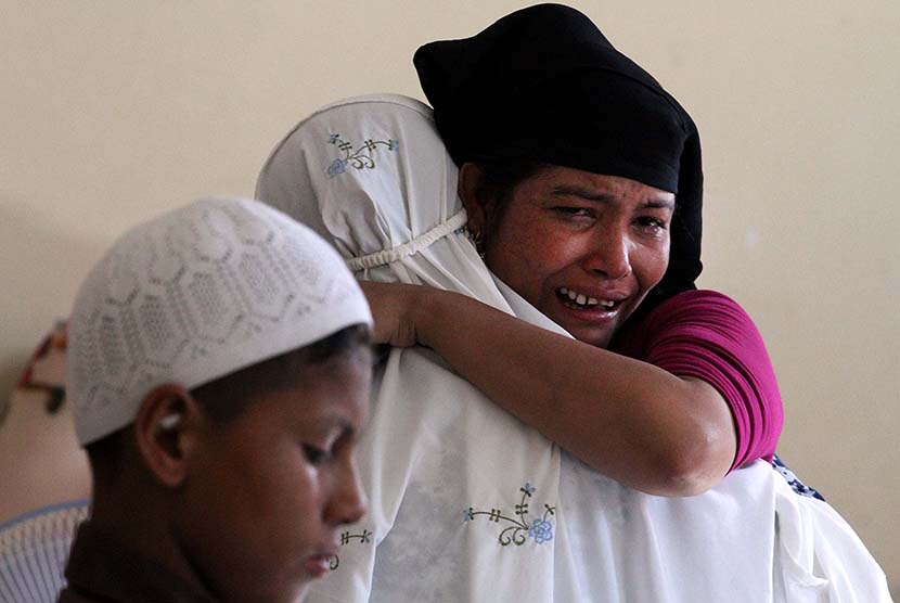 Pengungsi Rohingya saling berpelukan dan menangis usai melaksanakan salat Idul Fitri di penampungan sementara Desa Blang Ado, Kuta Makmur, Aceh Utara, Jumat (17/7).   (Antara/Rahmad)