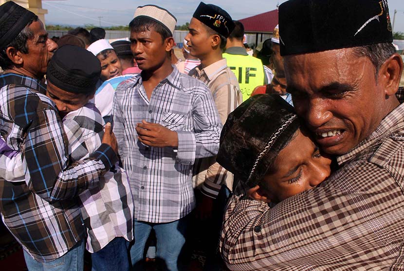 Pengungsi Rohingya saling berpelukan dan menangis usai melaksanakan salat Idul Fitri di penampungan sementara Desa Blang Ado, Kuta Makmur, Aceh Utara, Jumat (17/7).   (Antara/Rahmad)