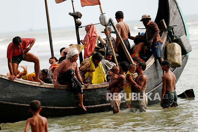 Pengungsi Rohingya turun dari perahu setelah berlayar di Teluk Bengal melintasi perbatasan Bangladesh-Myanmar di Teknaf, Bangladesh, Rabu (6/9).