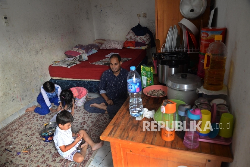 Pengungsi RohingyaKarimullah bercengkerama dengan anaknya di tempat kos di Jalan Karet Pedurenan, Jakarta Selatan, Senin (4/9)