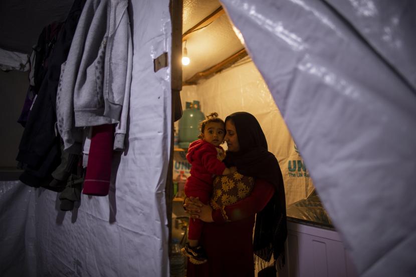 Pengungsi Suriah Ayesha al-Abed, 21, memegang dan mencium putrinya Rayan, 18 bulan, sebelum berbuka puasa pada hari pertama bulan puasa Ramadhan, di sebuah kamp pengungsi informal, di kota Bhannine di kota utara. dari Tripoli, Lebanon, Selasa, 13 April 2021.