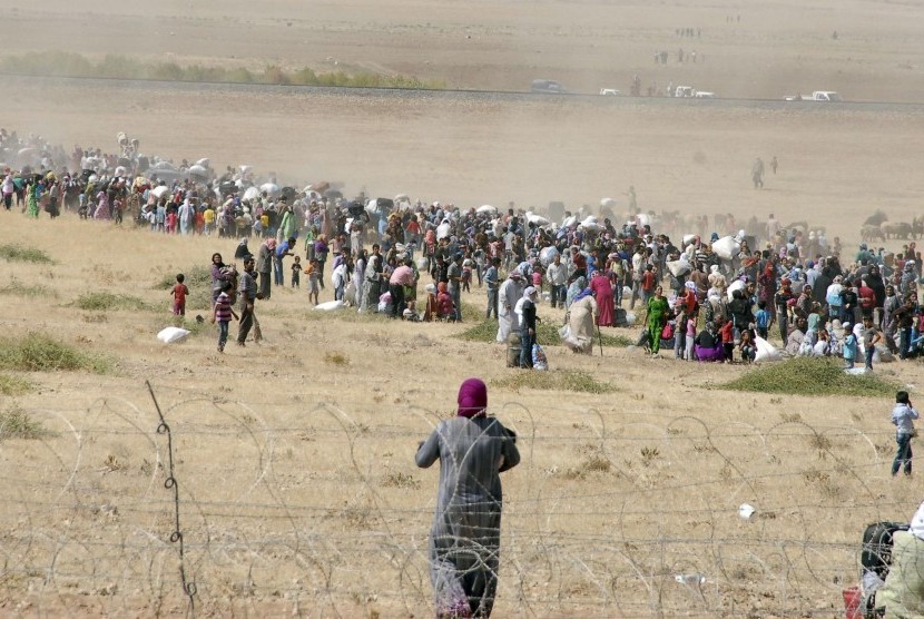 Pengungsi Suriah menuju perbatasan Turki di dekat Kota Kobani.
