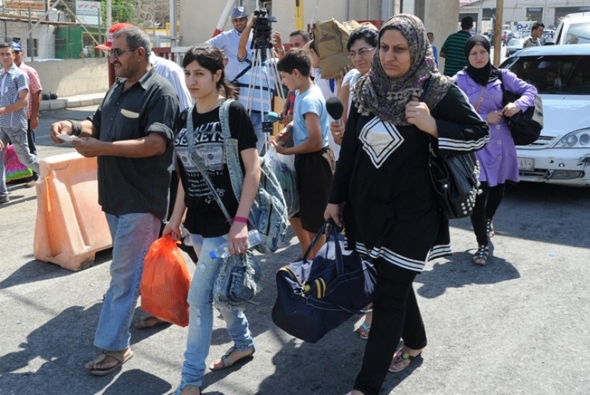 Pengungsi Suriah -- Pengungsi Suriah membawa barang-barang mereka saat menyeberang ke Libanon di perbatasan Masnaa, Libanon Timur, sekitar 40 kilometer (25 mil) dari Damaskus, Suriah, Jumat 20 Juli 2012. Mobil pribadi serta taksi dan bus membawa ribuan ora