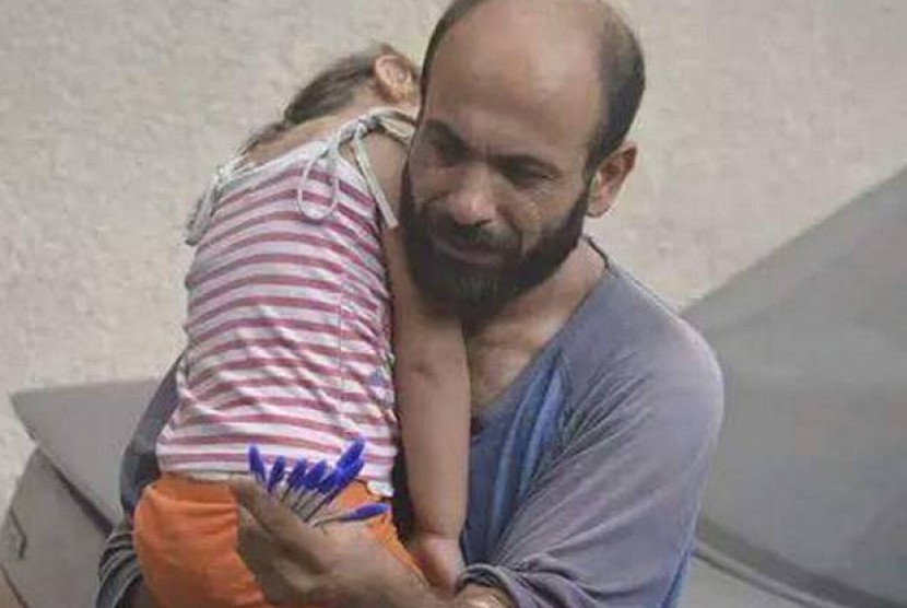 Pengungsi Suriah yang tinggal di Lebanon berjualan bolpoin dengan menggendong anaknya.