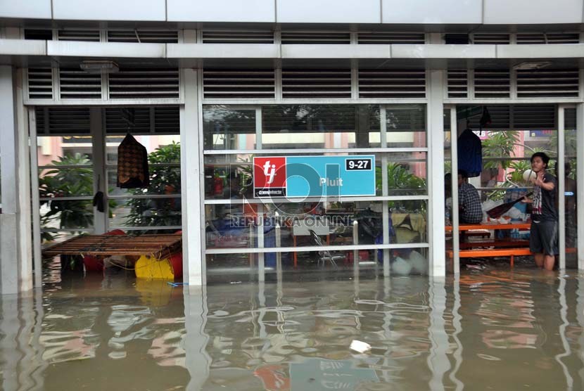  Pengungsi yang memanfaatkan Halte Transjakarta yang tidak beroperasi akibat banjir yang masih merendam kawasan Pluit, Penjaringan, Jakarta Utara, Ahad (20/1).  (Republika/Rakhmawaty La