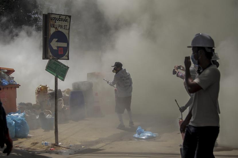  Pengunjuk rasa anti-kudeta melepaskan alat pemadam kebakaran untuk melawan dampak gas air mata yang ditembakkan oleh polisi anti huru hara selama demonstrasi di Yangon, Myanmar, Kamis, 4 Maret 2021. Demonstran di Myanmar yang memprotes kudeta militer bulan lalu kembali ke jalan pada hari Kamis, tidak gentar oleh pembunuhan sedikitnya 38 orang pada hari sebelumnya oleh pasukan keamanan.